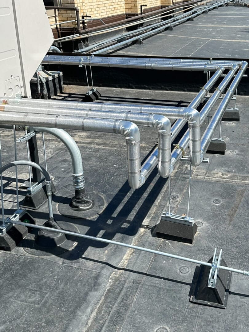 Rooftop HVAC piping with metal supports.