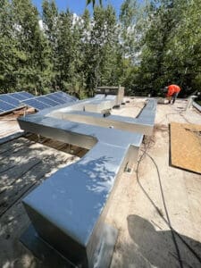 Rooftop solar panels with metal ductwork installed.